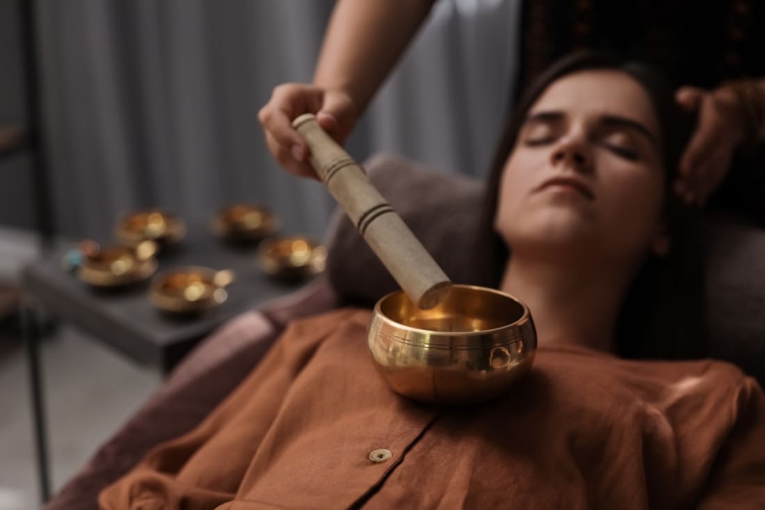 A sound massage with a Tibetan singing bowl performed on a woman