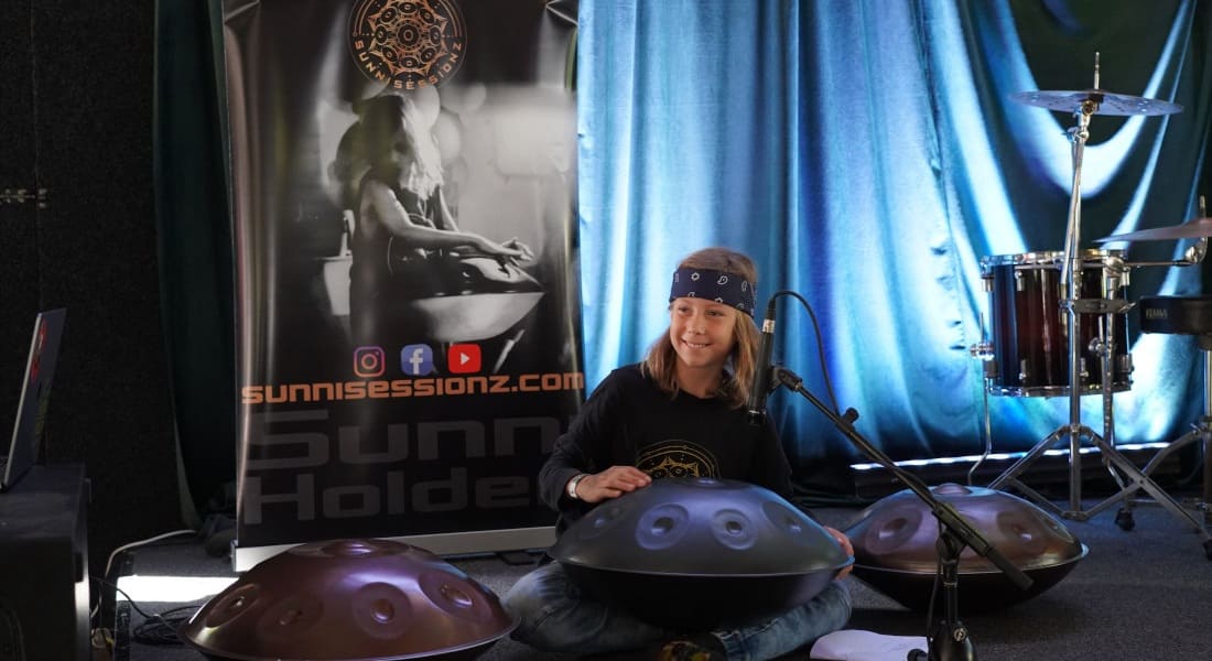 Sunni Holden seated and surrounded by several handpans