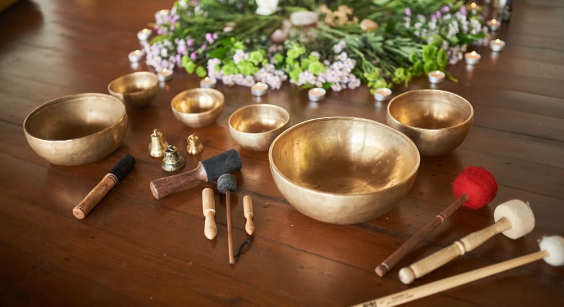 Several Tibetan singing bowls and mallets arranged on a table