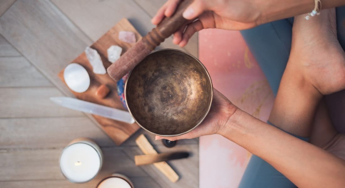 A top-down view of a person using a Tibetan singing bowl