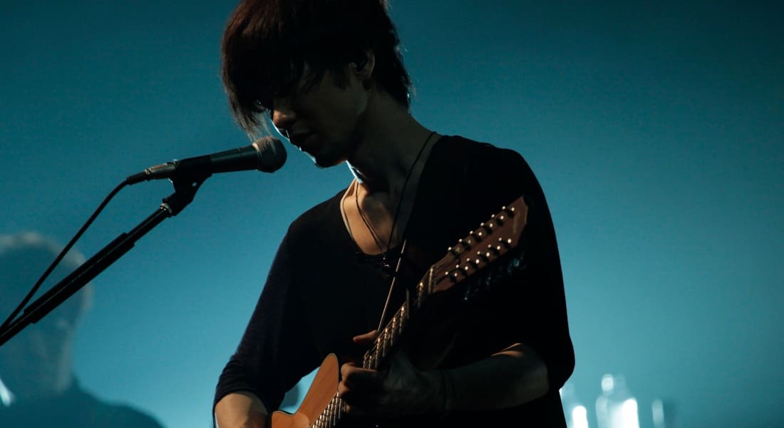 Toru Kitajima singing with a guitar