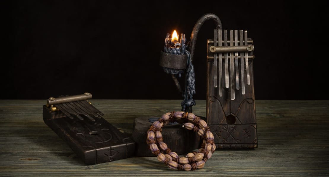 Two handcrafted kalimbas on a table with a candle