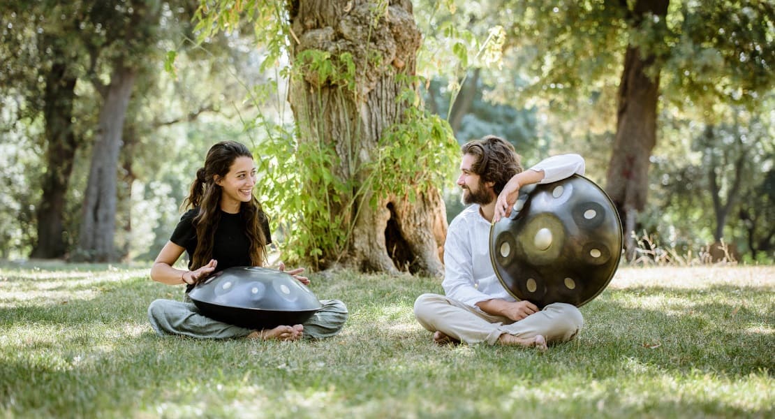 Two handpan players in the forest