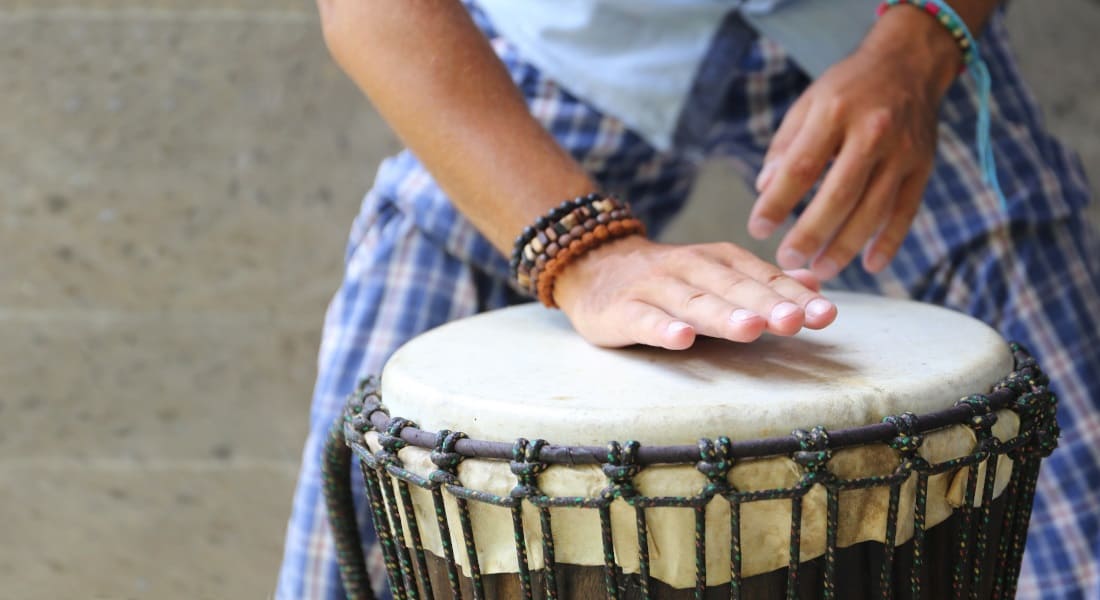 Two hands hitting a djembe skin