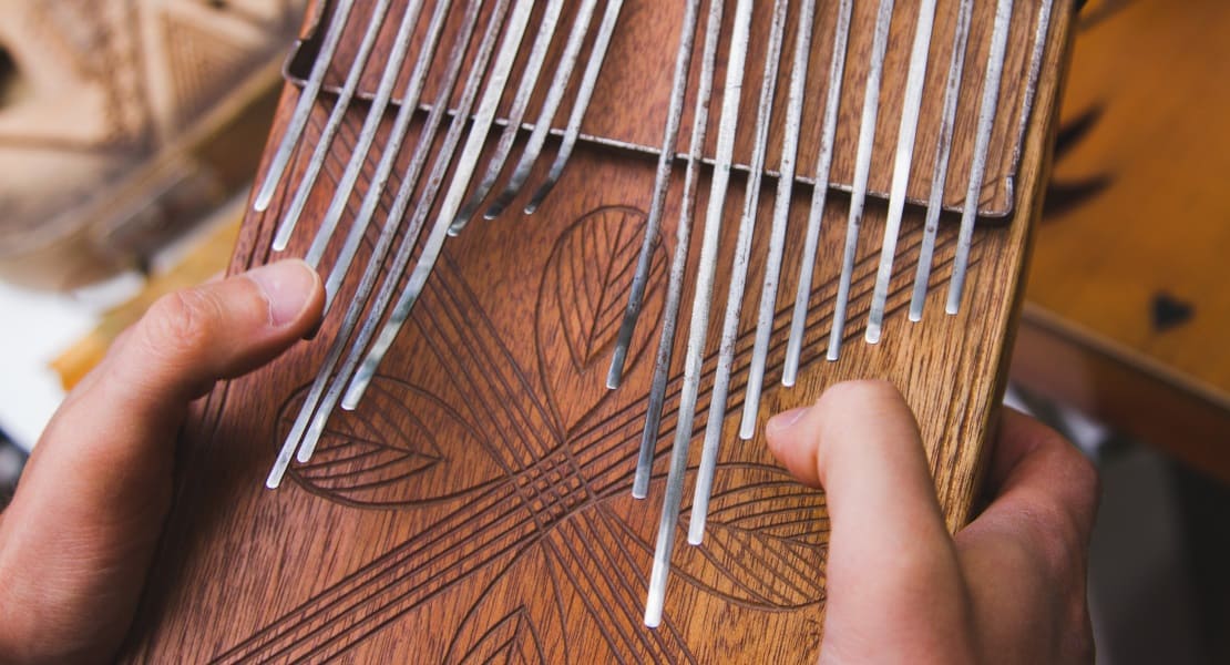 Two hands holding an old traditional kalimba