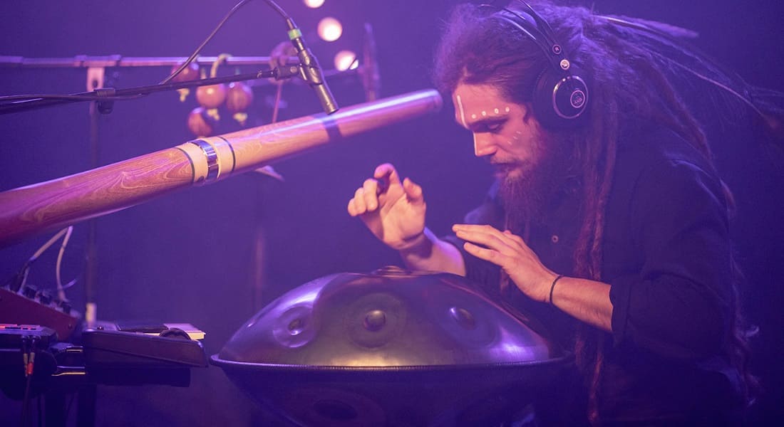 Waagal playing handpan and didgeridoo at a concert