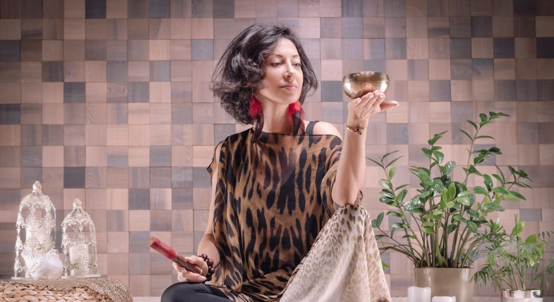 A woman looking at a 7-metal Tibetan singing bowl