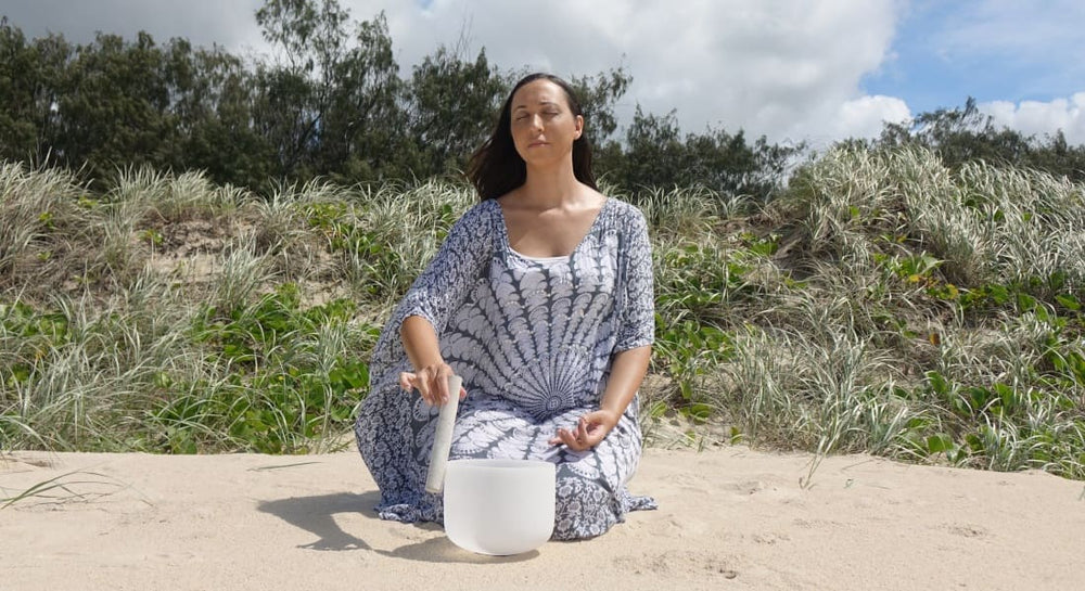 A woman playing a crystal singing bowl