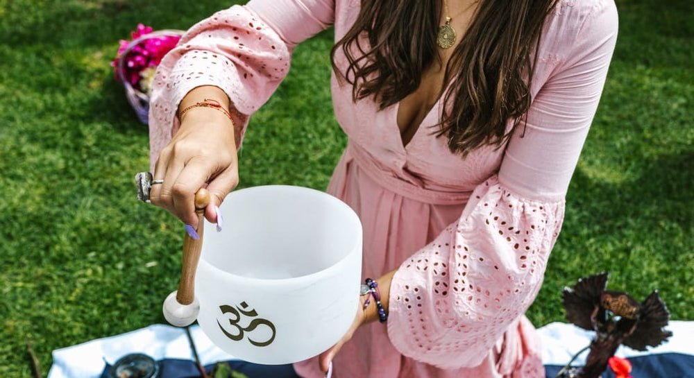 A woman playing a Tibetan singing bowl made of quartz crystal