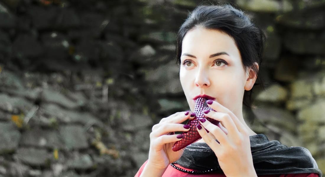 A woman playing a red ocarina