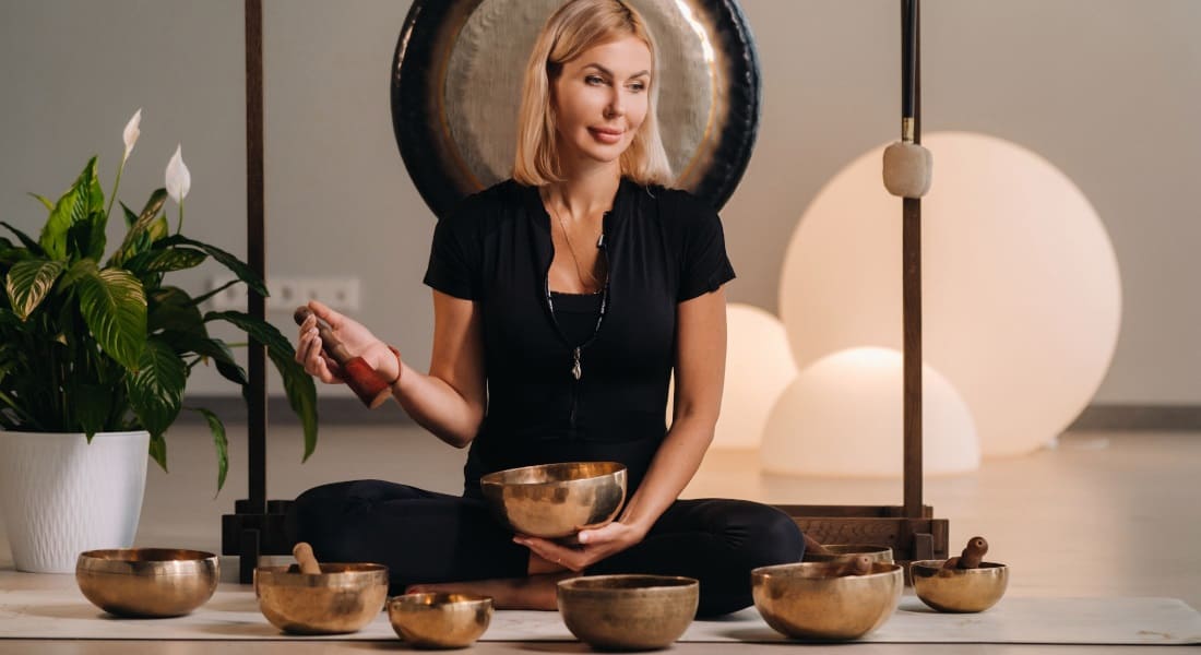 A woman practicing Reiki with Tibetan singing bowls