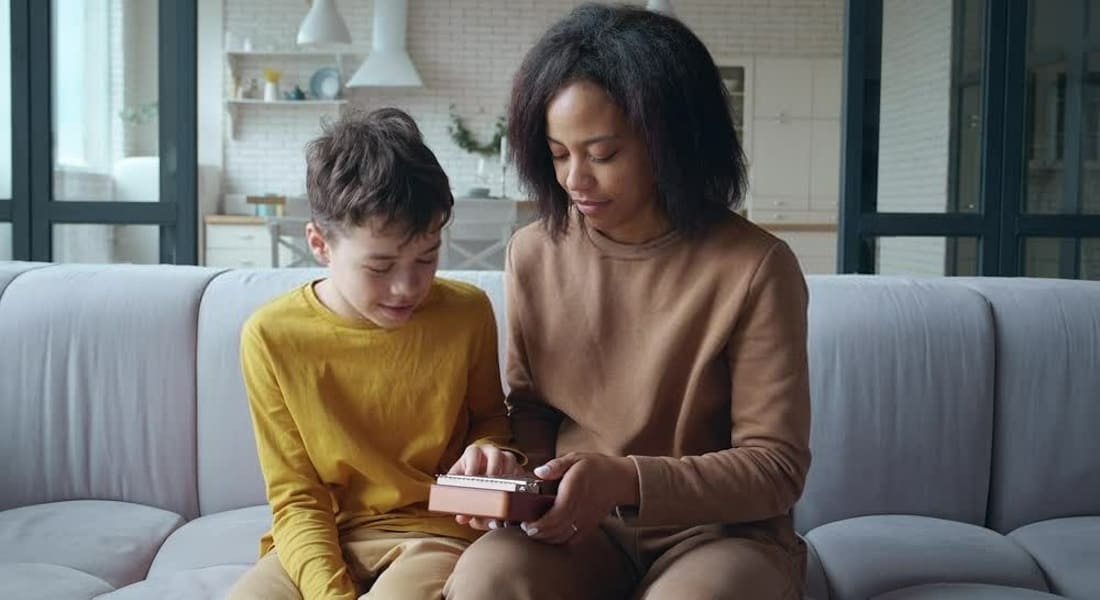 A woman showing a child how to play the kalimba