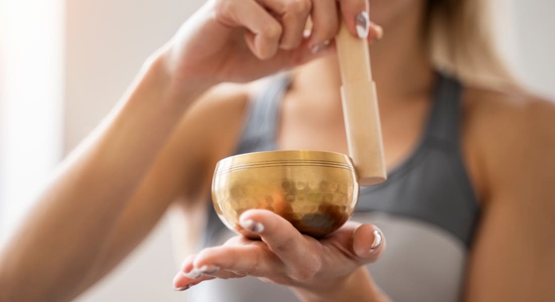 A woman using a Tibetan singing bowl