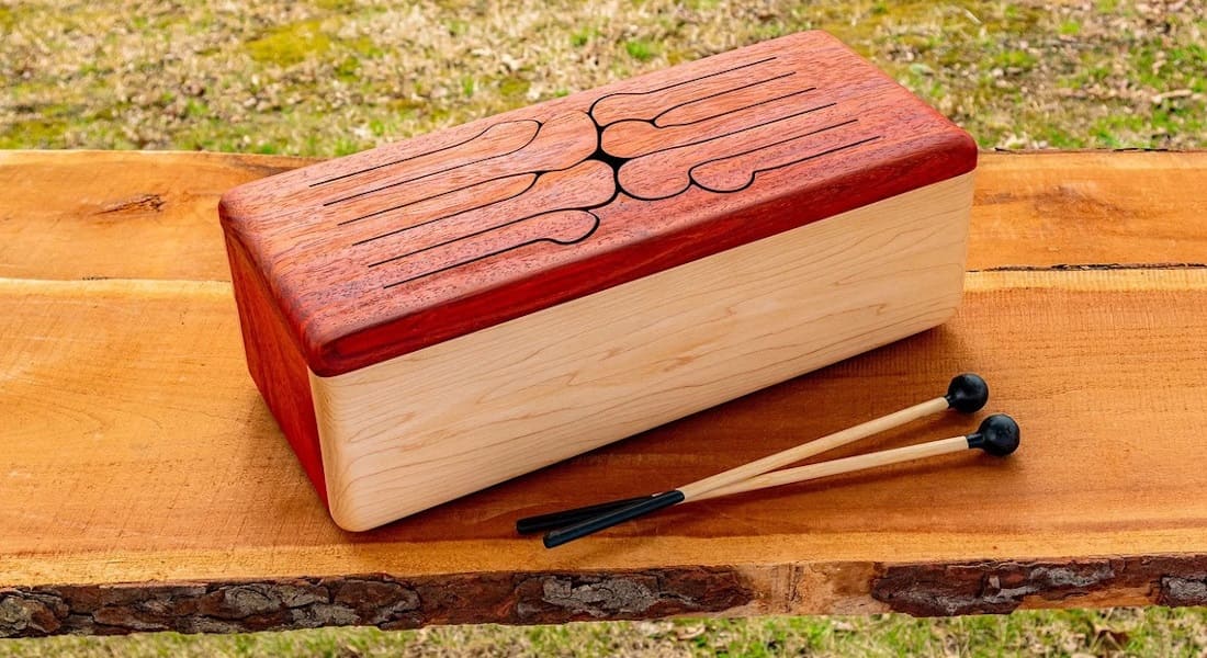 A wooden tongue drum on a bench