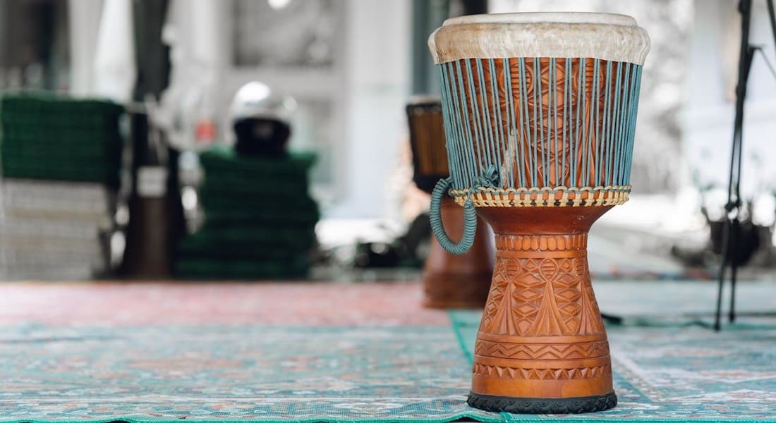 A wooden djembe on a rug